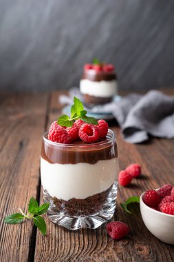 Lezzetli katmanlı krem peynirli tatlı, ezilmiş çikolatalı kurabiye, üstüne ganache ve kavanozda taze ahududu.