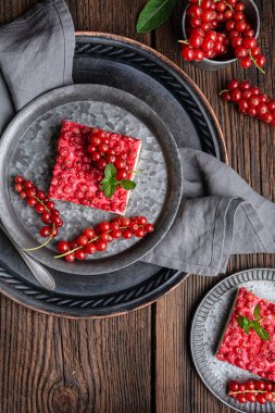 Krem peynirle doldurulmuş, ahşap arka planda taze böğürtlenlerle süslenmiş üzümlü tatlı.
