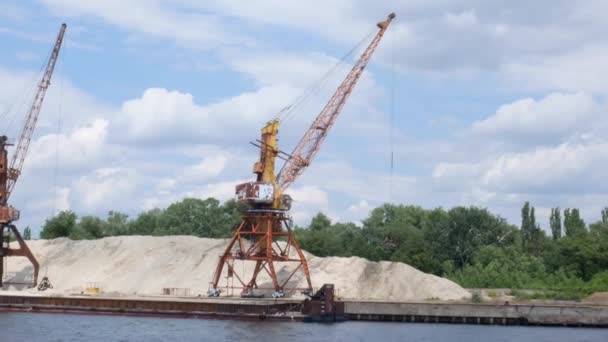 河岸上的两台港口起重机产沙 港口起重机用水桶在河岸上 提取河沙 港口货运起重机提取河沙 — 图库视频影像
