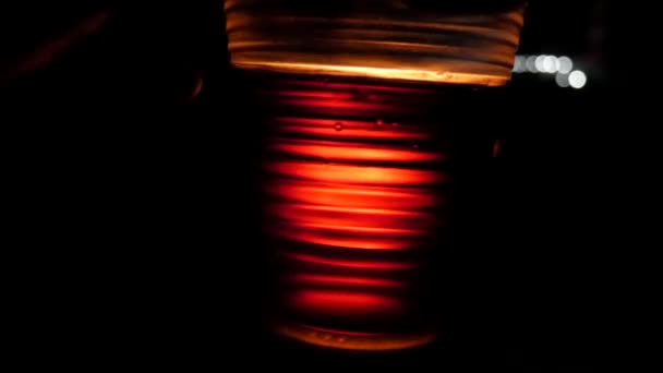 Doorzichtige Plastic Beker Gevuld Met Cognac Flikkert Vuur Achtergrond Nachts — Stockvideo