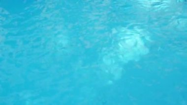 Alt kısmında mavi fayans ile bir yüzme havuzunda temiz su yüzeyi