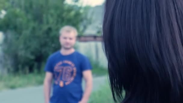 The girl goes towards the guy and straightens her hair — Stock Video