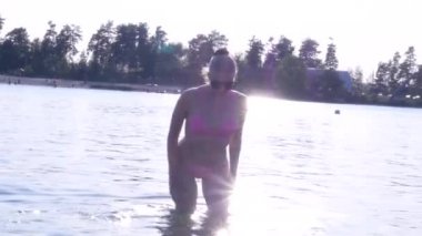 Gün batımında bir gölde bikini seksi sarışın kız
