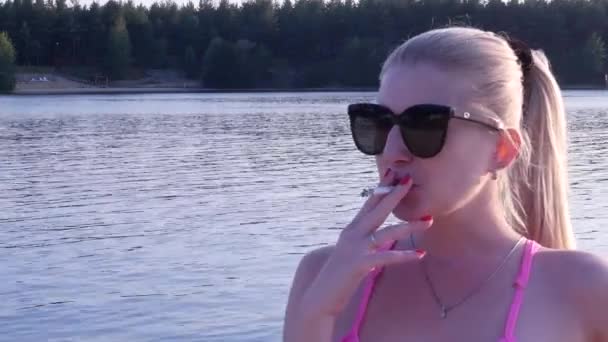 Hermosa chica fumando cigarrillo al atardecer — Vídeo de stock
