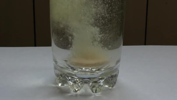 発泡性ビタミンC錠剤がコップ1杯の水に落ちた フィジーピルのスローモーション映像を失い 泡で溶解します ビタミン飲料医学 ヘルスケア薬局化学概念 — ストック動画