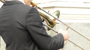 Açık hava konserinde trombon çalan erkek.