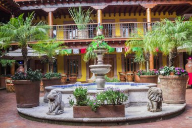 Otel bahçesindeki antik çeşme. Taş çeşmeden akan mavi su. Antik Çeşmenin Tasarımı Patzcuaro Meksika