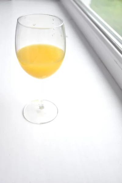 beyaz bir pencere üzerinde portakal suyu cam