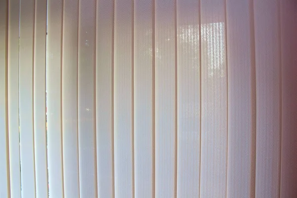 büyük bir pencerede beyaz güneşlikler