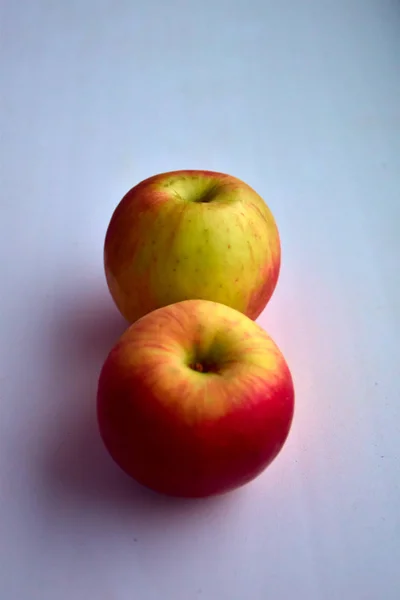 beyaz bir pencere üzerinde iki olgun elma