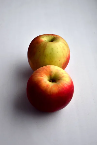 beyaz bir pencere üzerinde iki olgun elma