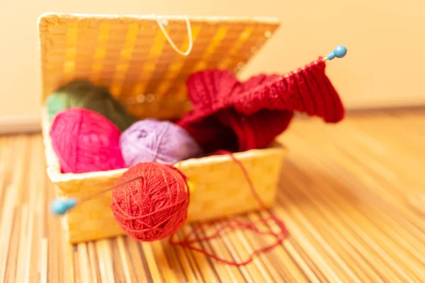 Hasır sepette örmek için çok renkli yün topları.