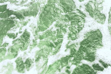 Deniz suyunun turkuaz köpüklü yüzeyi, üst görünüm.