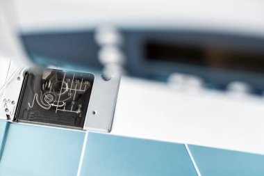 Dikiş için denim ve iplik ile dikiş makinesi, yakın çekim. Mavi bezli dikiş makinesinin bir parçası.