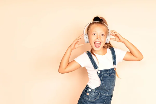 Küçük kız kulaklıkla bir şarkı dinliyor. Müzik konseptinin keyfini çıkarın.