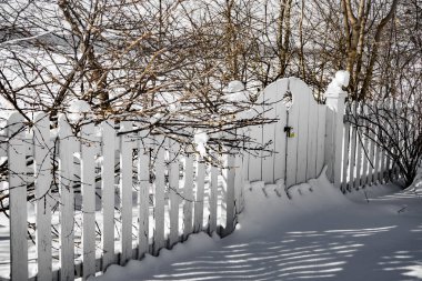 kış bahçesinde karlı kaplı beyaz çit ve kapı