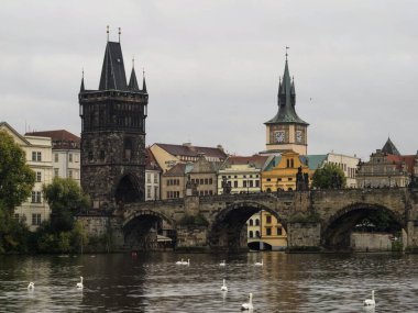 Prag 'da Vltava Nehri, bulutlu bir günde arkasında Charles Köprüsü ile Çek Cumhuriyeti