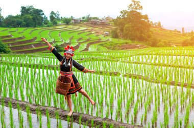 Manzara, dağlar ve tarlalarda tepe kabilesi kadın gün doğumunda yeşil ağaçlar var.