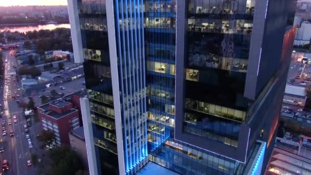 日没時の開放的な川のパノラマを持つ市内のオフィスビルを越えて飛ぶ — ストック動画