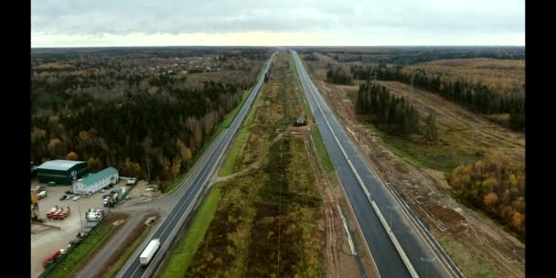 営業道路に平行森の中に新しい高速道路の建設の空中ビュー ドローンからのパノラマビュー — ストック動画