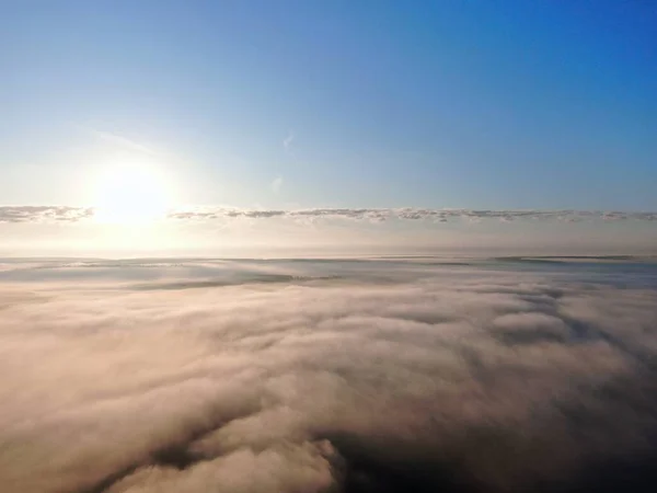 Aerial view of drone flight above clouds at dawn with fog. — Stock Photo, Image