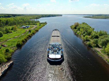 Hava görüntüsü kargo gemisi nehirden aşağı süzülüyor. Ormanla çevrili. Yükseklikten güzel panoramik manzara