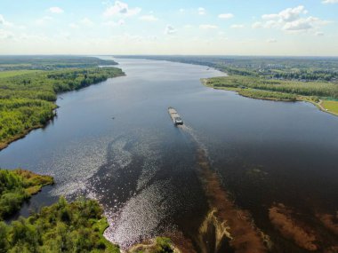 Hava görüntüsü kargo gemisi nehirden aşağı süzülüyor. Ormanla çevrili. Yükseklikten güzel panoramik manzara