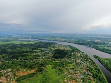 Ufkun ötesindeki büyük bir nehirden gelen güzel panoramik manzara yazın güneşli bir günde yeşil ormanla çevrili.