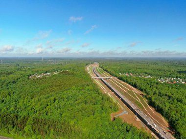 Yüksek irtifa otobanından güzel panoramik manzara ufkun ötesine doğru gidiyor yazın güneşli bir günde yeşil ormanla çevrili.