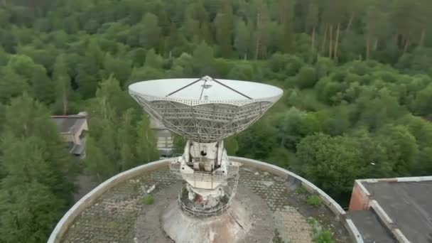 空中からの眺めは緑の森を背景にした電波望遠鏡の大きな宇宙アンテナです 宇宙通信装置 — ストック動画