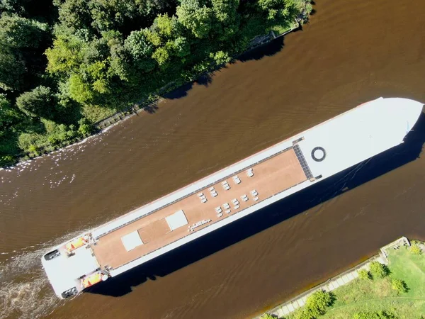 Aerial view journey by passenger cruise ship on the river. Beautiful panoramic landscape from a height ship sails along a large river against the background of water and clouds