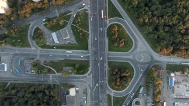 Gün batımında Moskova 'da çok katlı bir taşıma kavşağında havadan uçuş. Şehirdeki otoyolda araba trafiği. İnsansız hava aracından şehir manzarası