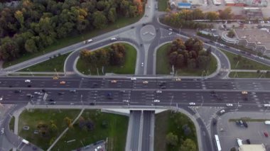 Gün batımında Moskova 'da çok katlı bir taşıma kavşağında havadan uçuş. Şehirdeki otoyolda araba trafiği. İnsansız hava aracından şehir manzarası