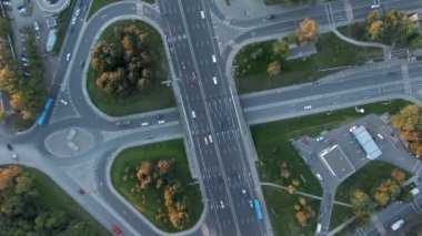 Gün batımında Moskova 'da çok katlı bir taşıma kavşağında havadan uçuş. Şehirdeki otoyolda araba trafiği. İnsansız hava aracından şehir manzarası