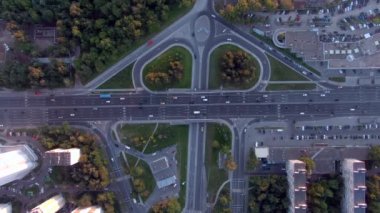 Gün batımında Moskova 'da çok katlı bir taşıma kavşağında havadan uçuş. Şehirdeki otoyolda araba trafiği. İnsansız hava aracından şehir manzarası