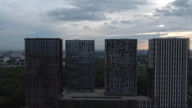 Yeni ofis kuleleri ve alışveriş merkezinin hava manzaralı inşaatı. Yeşil ormanın arka planına karşı şehir manzarası