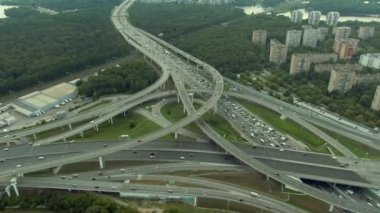 Gün batımında Moskova 'da çok katlı bir taşıma kavşağında havadan uçuş. Şehirdeki otoyolda araba trafiği. İnsansız hava aracından şehir manzarası