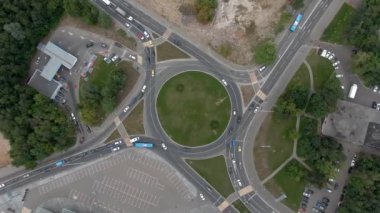 Büyük şehirde bir kavşakta hava manzaralı araba trafiği. Sarmal olarak tepeden tırnağa İHA uçuşu
