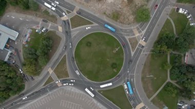 Büyük şehirde bir kavşakta hava manzaralı araba trafiği. Sarmal olarak tepeden tırnağa İHA uçuşu