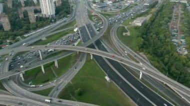 Gün batımında Moskova 'da çok katlı bir taşıma kavşağında havadan uçuş. Şehirdeki otoyolda araba trafiği. İnsansız hava aracından şehir manzarası