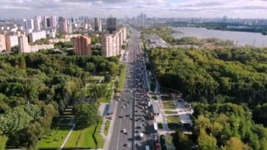 Büyük şehirdeki otoyolda hızlandırılmış araba trafiği. İnsansız hava aracıyla güzel şehir manzarası