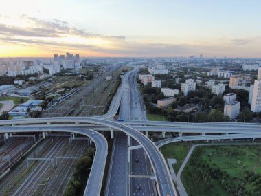 Gün doğumunda Moskova 'nın panoramik manzarası. Şehirdeki bir otoyolda, altın güneş ışınlarının altında çok katlı bir kavşak. İHA atışı