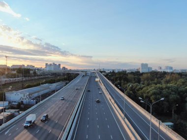 Gün doğumunda Moskova 'nın panoramik manzarası. Şehirdeki bir otoyolda, altın güneş ışınlarının altında çok katlı bir kavşak. İHA atışı