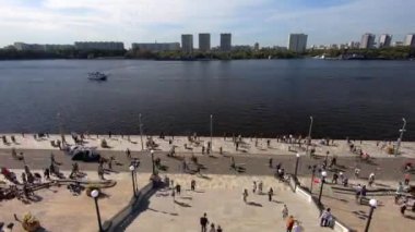 Timelapse güneşli bir günde Moskova 'daki yenilenmiş Kuzey Nehri İstasyonu' nun meydanında insanları gezdirir. Şehir parkında aile tatili
