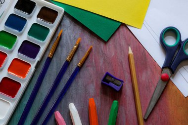 Çocuklar ve yaratıcılık için kırtasiye - suluboya, fırçalar, makas, renkli kağıt, pastel ve bileyici.