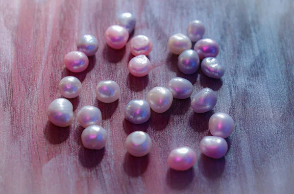 粉红色 白色和蓝色珍珠特写在浅珍珠木制背景上 — 图库照片