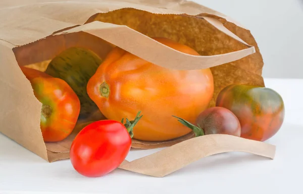 纸包附近的几个不同档次的西红柿 — 图库照片
