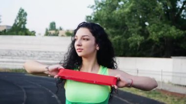 bir spor yeşil üst güzel genç kız stadyumda fitnesss için elastik ile meşgul