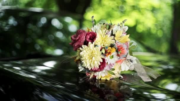 Ein Schöner Hochzeitsstrauß Aus Blumen Liegt Auf Der Motorhaube Des — Stockvideo