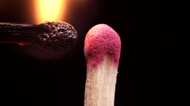 Le match s'allume et s'allume au ralenti en gros plan sur fond noir 